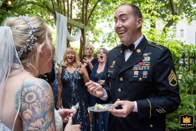 Bride laughs as groom playfully smears cake on her face in the charming courtyard of the Kehoe House in Savannah, GA.